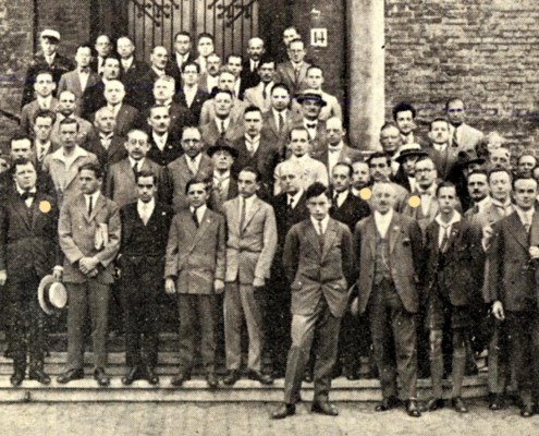 1928 - Haga. Fotografie de grup cu participanţii la Olimpiadă. Jucătorii români (marcaţi cu bulină): în primul rând (stânga): Nicolae Brody şi Ion Gudju, iar în rândul al doilea, în dreptul stâlpului (din dreapta): Zeno Proca şi Ioan Balogh.